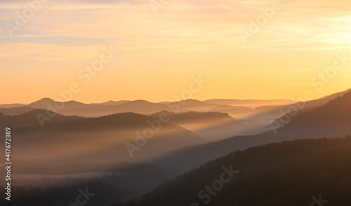 sun rays lighting a foggy valley during sunrise © Africa2008