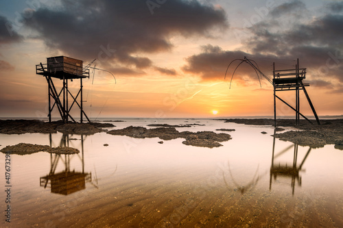 Fishing huts on beach at low tide at sunset, Saint-Michel-Chef-Chef, Loire-Atlantique, France