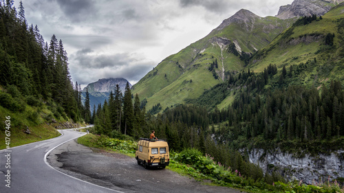 Photo camper van in the forest mountain road in the mountains