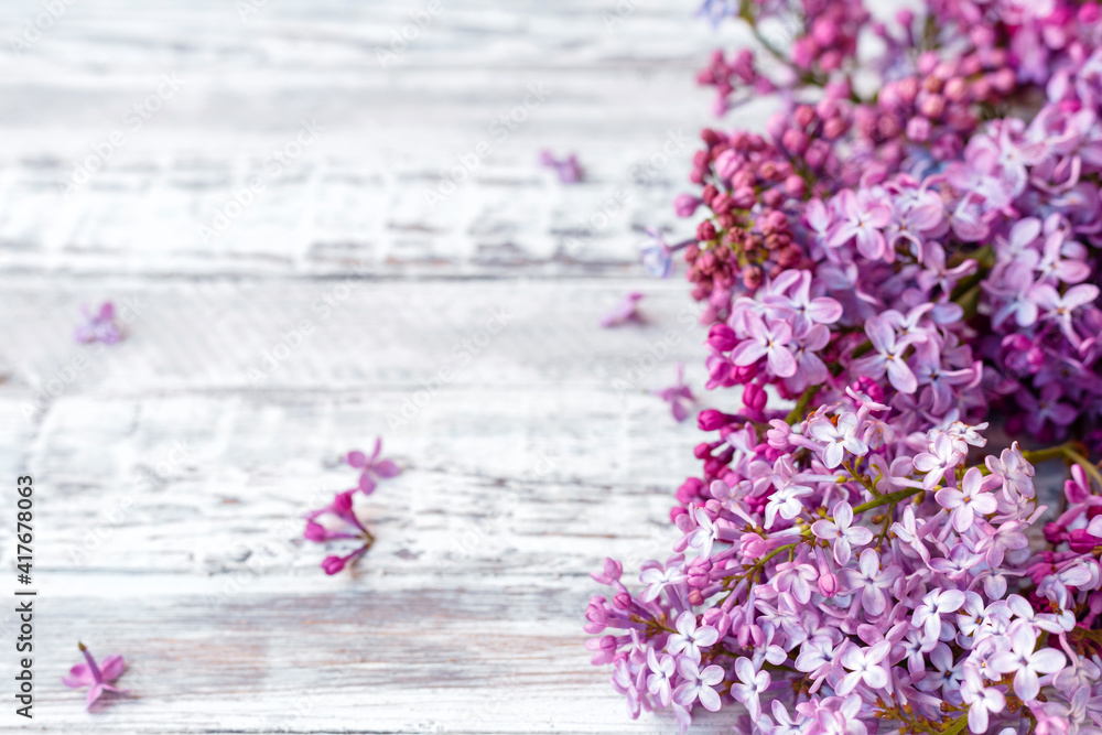 Obraz premium Purple lilac Spring branches of blooming lilac festive bouquet of flowers with copy space. Purple lilac branch on table, floral still life on gray wooden background.