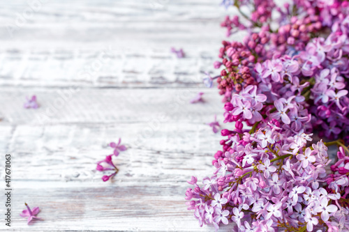 Purple lilac Spring branches of blooming lilac festive bouquet of flowers with copy space. Purple lilac branch on table, floral still life on gray wooden background.