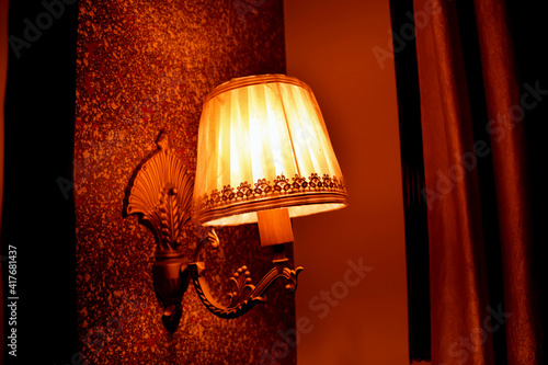 Antique electronic lamp, red wall lamp, high wall lamp, soft light.Red brick wall.Open chain, turn off the lights.hanging at the red brick wall in the building. Selective Focus On Subject.