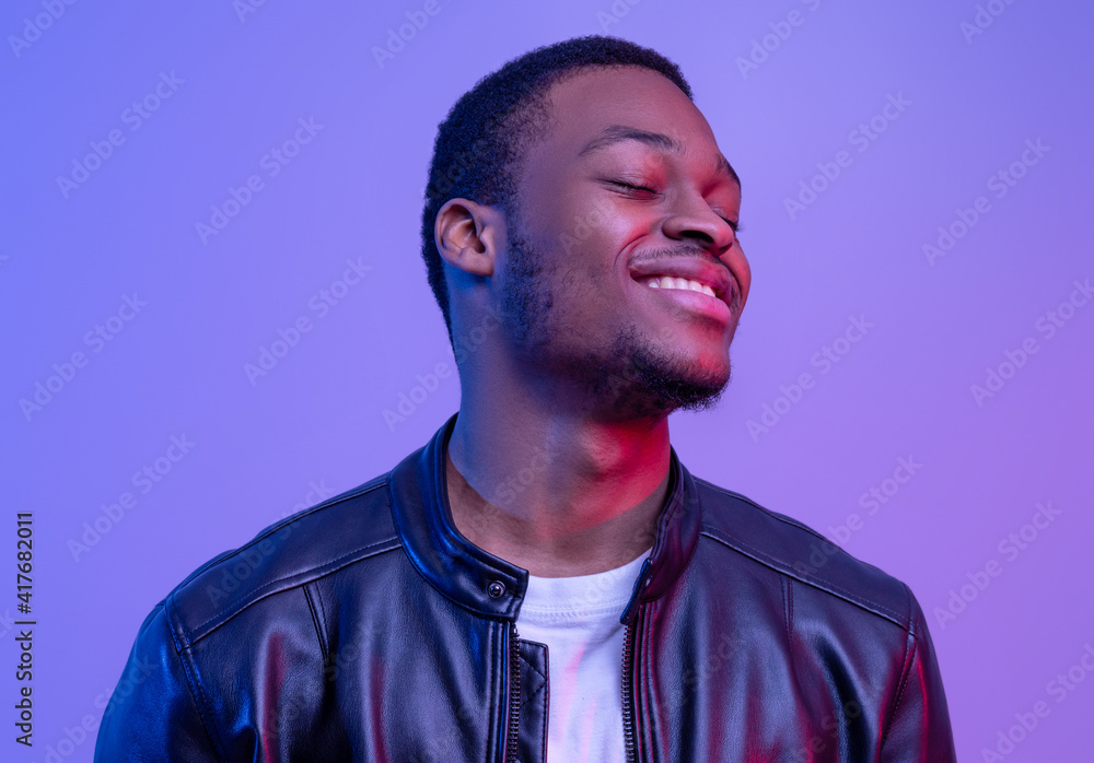 Closeup Of Satisfied Black Guy In Leather Jacket Standing With Closed Eyes