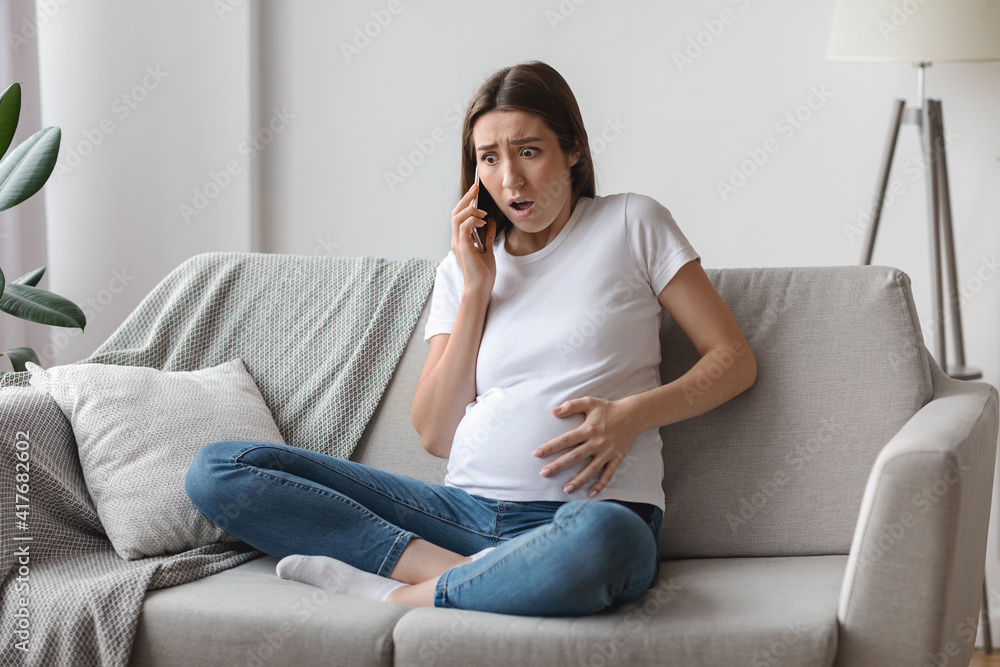 Labor Time. Worry Pregnant Woman Calling To Doctor, Feeling Cramps In Abdomen Labor Time. Worry Pregnant Woman Calling To Doctor, Feeling Cramps In Abdomen