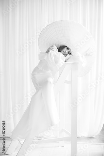 Fashion studio photo of elegant lady in giant white hat. Health and beauty