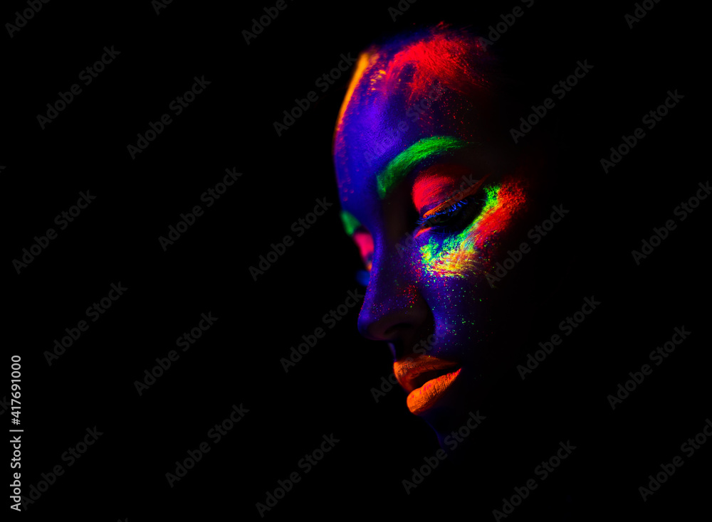 trendy neon makeup on the model. Woman with ultraviolet make-up. Disco night club chameleon. UV colors. Fashion of the future bright appearance. face Art. Copy space for text background trendy neon makeup on the model. Woman with ultraviolet make-up. Disco night club chameleon. UV colors. Fashion of the future bright appearance. face Art. Copy space for text background