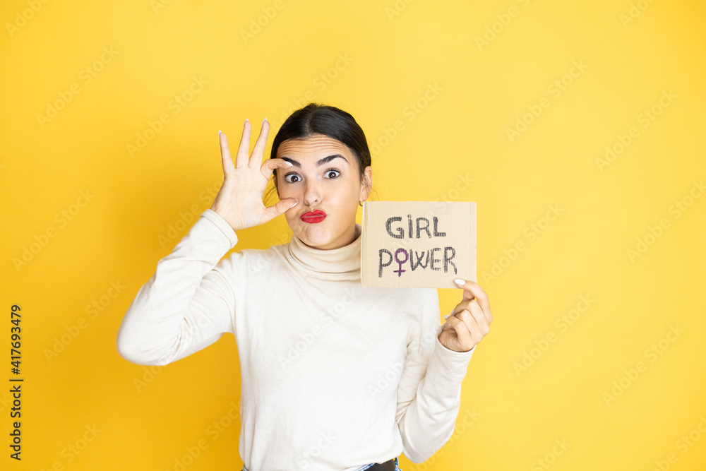 Young beautiful activist woman protesting holding poster with girl power message Trying to open eyes with fingers, sleepy and tired for morning fatigue Young beautiful activist woman protesting holding poster with girl power message Trying to open eyes with fingers, sleepy and tired for morning fatigue