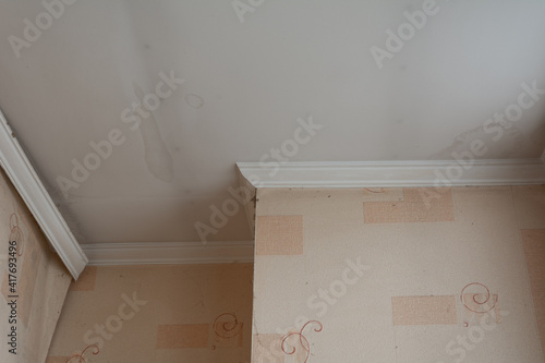 Roof leaks, marks on the white painted ceiling after rain or melting snow. Apartment renovation.