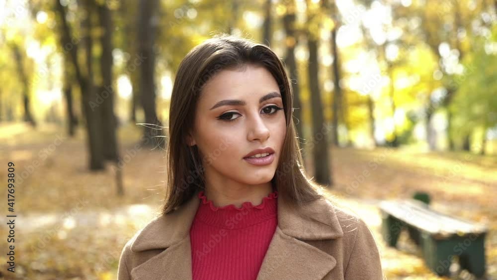 Passionate look into camera of brunette with brown eyes during a walk in park Passionate look into camera of brunette with brown eyes during a walk in park