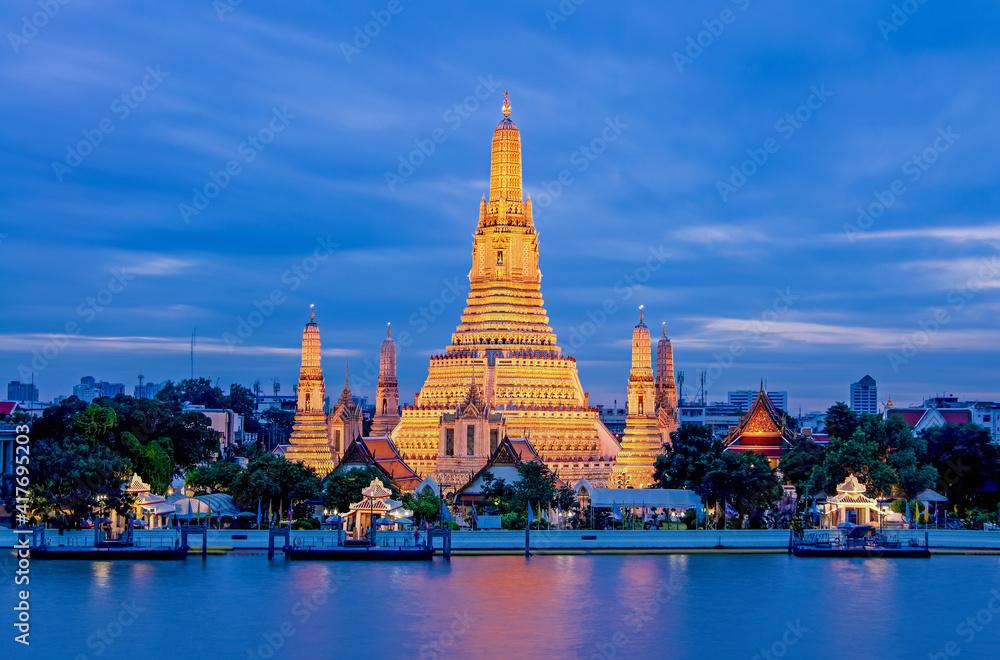 Fototapeta premium Arun Worawihan Temple Located on the Chao Phraya River, Thailand. At night the light illuminates the beautiful water.