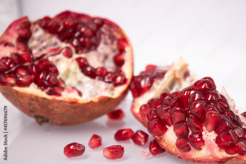 ripe fresh sliced pomegranate fruit with red seeds isolated on white background ripe fresh sliced pomegranate fruit with red seeds isolated on white background