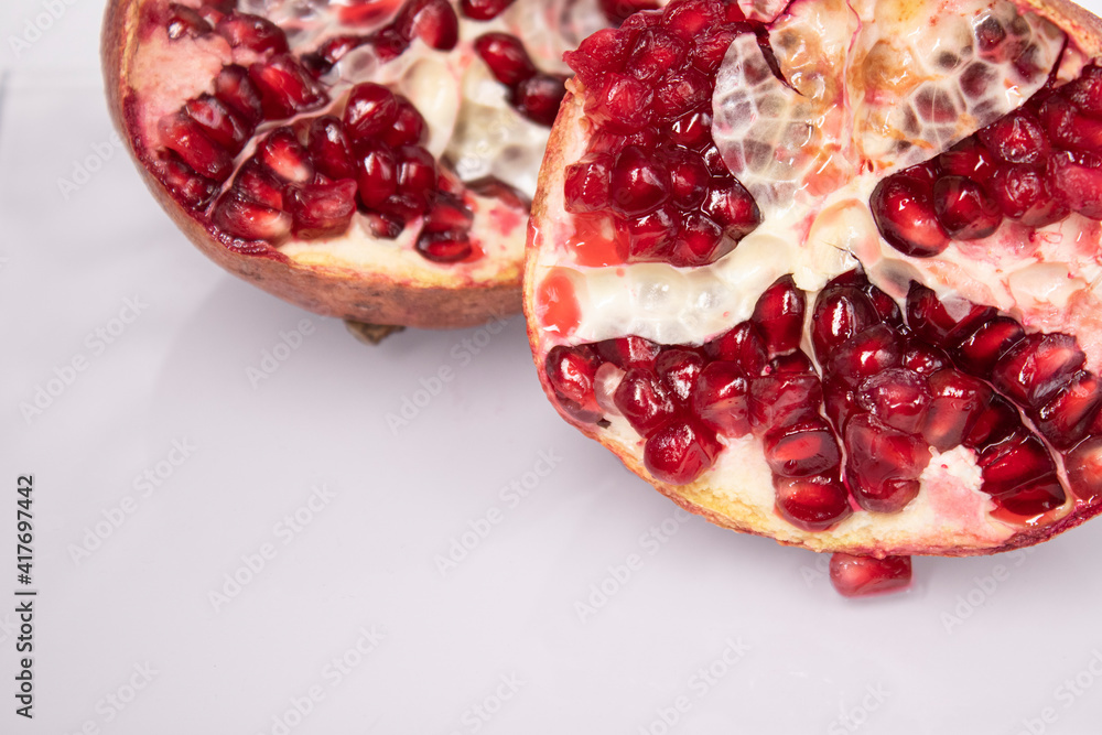 ripe fresh sliced pomegranate fruit with red seeds isolated on white background ripe fresh sliced pomegranate fruit with red seeds isolated on white background