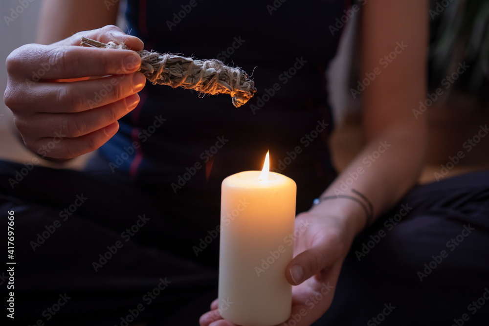 Woman burning sage incense with candle.preparation for energy cleaning for negative energy. Woman burning sage incense with candle.preparation for energy cleaning for negative energy.