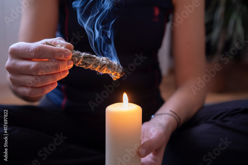 Woman's hand burning white sage in home. photo