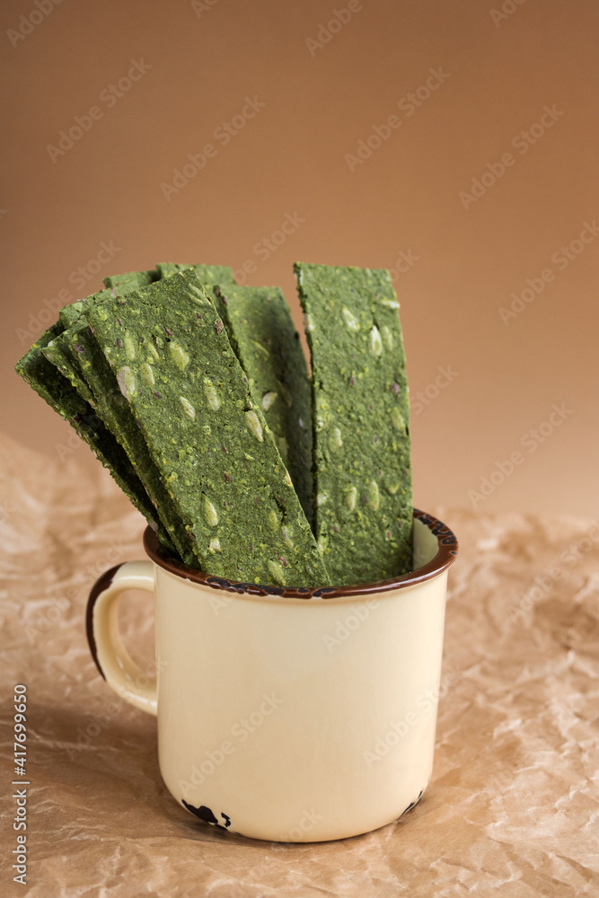 Vegetarian chips with seaweed. Crispy chips with spirulina, flax seeds, ginger and wasabi on craft paper. Marine multi-snacks. Superfood. The concept of proper nutrition. Vegetarian chips with seaweed. Crispy chips with spirulina, flax seeds, ginger and wasabi on craft paper. Marine multi-snacks. Superfood. The concept of proper nutrition.