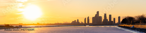 Photography Panorama of waterfront apartment buildings skyline silhouetted in front of a war