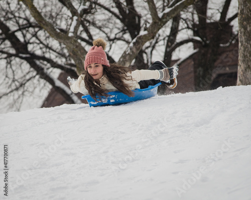 Girl sledding down hill