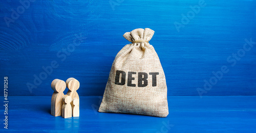 Family figurines and Debt money bag. Financial literacy. Arrears difficult financial situation. Debts restructuring. Inability to repay. Falling living standards, social complex. Refinancing photo