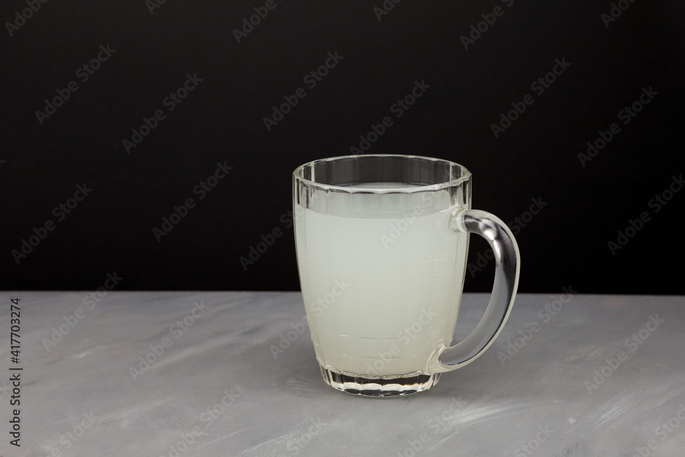 Homemade ginger Kombucha or milk-white kvass in a large glass mug. Healthy fermented drink. Dark background, copy space Homemade ginger Kombucha or milk-white kvass in a large glass mug. Healthy fermented drink. Dark background, copy space