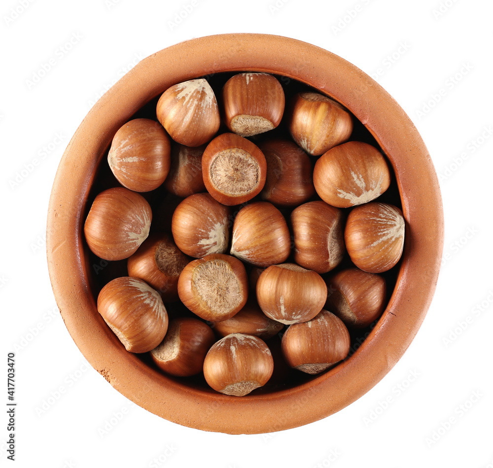 Hazelnuts in clay pot isolated on white background, top view Hazelnuts in clay pot isolated on white background, top view