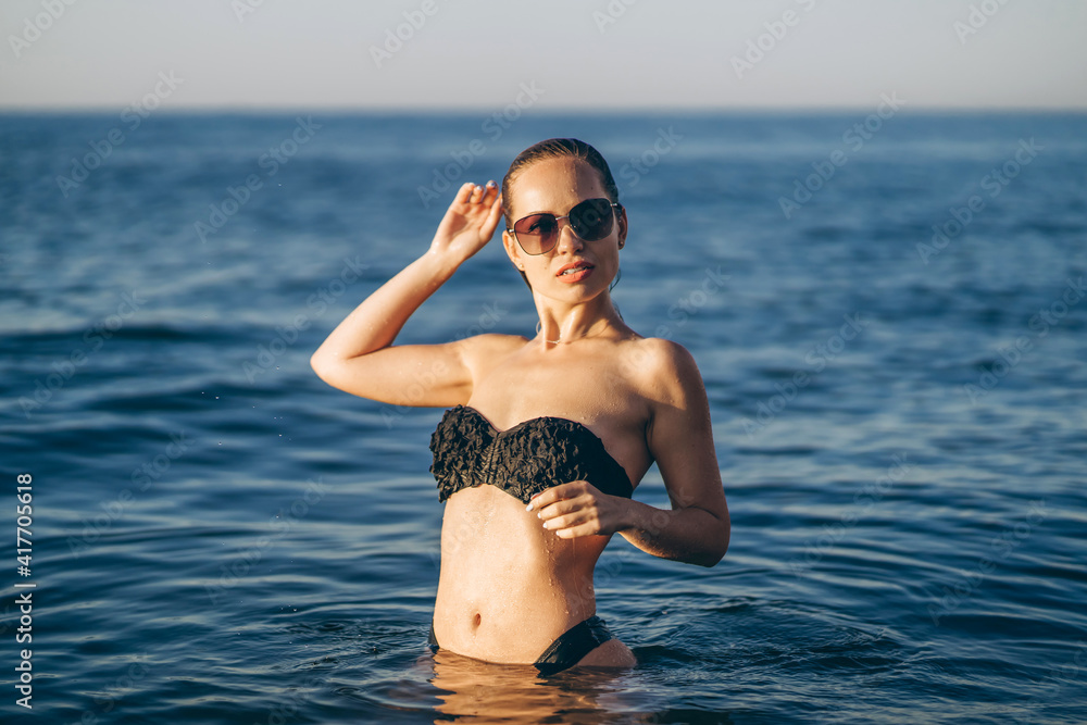 Pretty brunette woman relaxing on the beach at the sea. Pretty brunette woman relaxing on the beach at the sea.