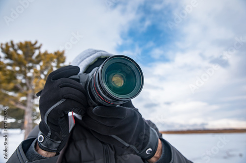 man holding camera in snowy nature © Daniel