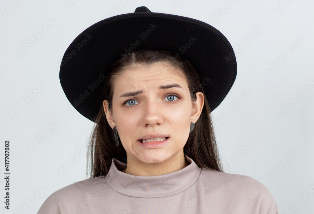 Indoor shot of cute girl looking at the camera, having doubtful and indecisive face expression, pursuing her lips as if forbidden to say anything. Confused young female posing isolated at white wall Indoor shot of cute girl looking at the camera, having doubtful and indecisive face expression, pursuing her lips as if forbidden to say anything. Confused young female posing isolated at white wall