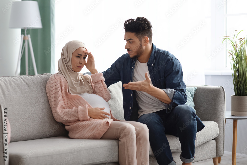 Agressive arab man arguing with his upset pregnant muslim wife at home Agressive arab man arguing with his upset pregnant muslim wife at home