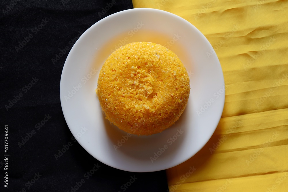 Brazilian Couscous on black and yellow background, with place for text. Corn couscous. Brazilian food. Brazilian Couscous on black and yellow background, with place for text. Corn couscous. Brazilian food.