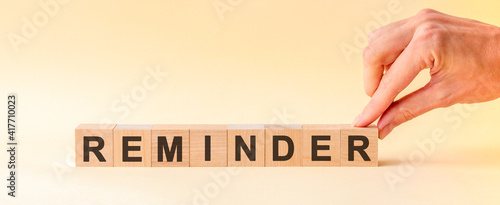 Φωτογραφία woman made word REMINDER with wood blocks