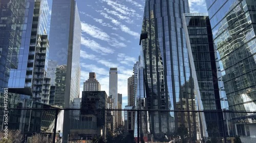 driving past trees behind fence skyscrapers Hudson Yards Midtown Manhattan New York City NYC