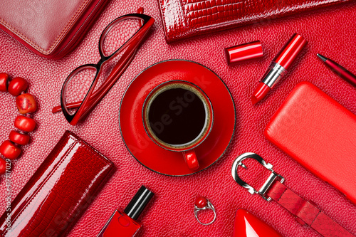 Woman red accessories with coffee, cosmetic, jewelry, gadget and other objects on leather background, fashion industry, modern female concept, selective focus  photo