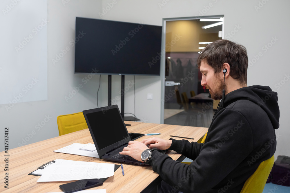 Young businessman working at his desk, office laptop. Business, consultations, online training, coworking Young businessman working at his desk, office laptop. Business, consultations, online training, coworking
