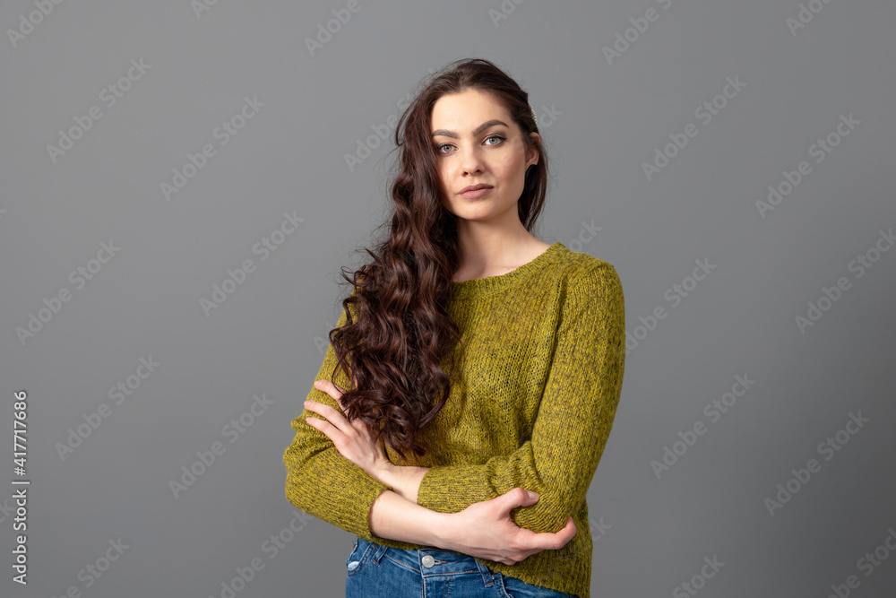 portrait of beautiful sensual woman with long curly hair against gray background portrait of beautiful sensual woman with long curly hair against gray background