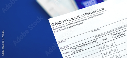 COVID-19 vaccination record card close up on table in hospital