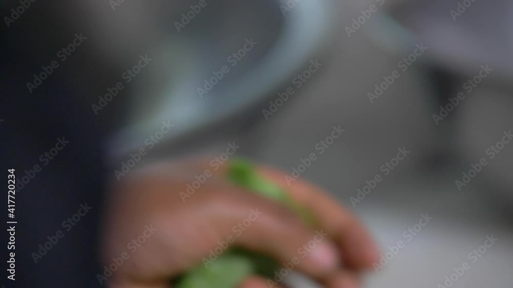 Cook hands slowly slicing nopales with a small knife Cook hands slowly slicing nopales with a small knife