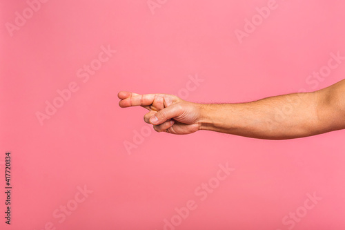 Caucasian male hand point finger. Hand gestures - man pointing at virtual object with index finger isolated on pink background.