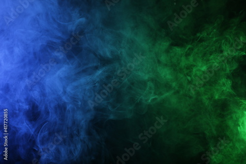 Smoke in blue green light on black background