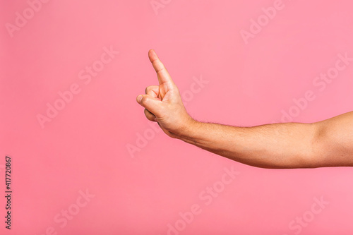 Caucasian male hand point finger. Hand gestures - man pointing at virtual object with index finger isolated on pink background.