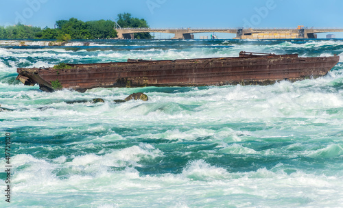 Fotografie, Obraz The Niagara Scow sits in the raging water of the Niagara River close to the edge of the Horseshoe Falls in Niagara Falls Canada