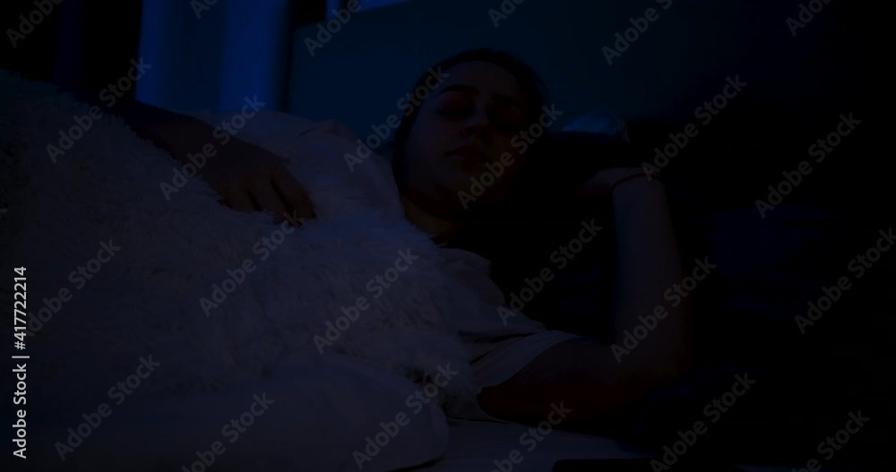 A woman, lying in bed, wakes up, turns on the light. A woman, lying in bed, wakes up, turns on the light.