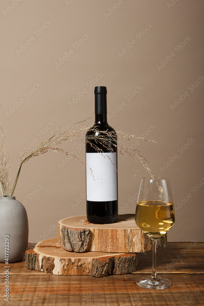 Naklejka premium Blank white label mock up on black bottle of unlabeled wine on a wooden table. Alcohol bottle mockup presentation ready for logo design. Full drink bottle template with empty sticker.