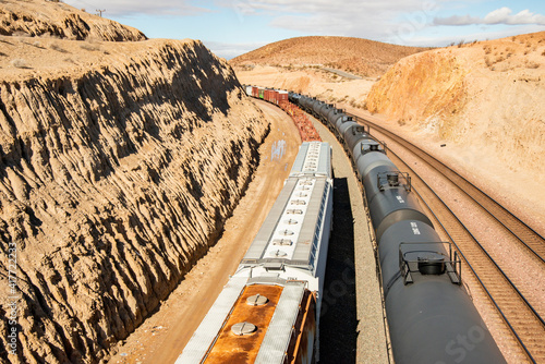 USA, California, Barstow. Freight trains in carved out track path, seen from North Yucca Avenue overpass. photo