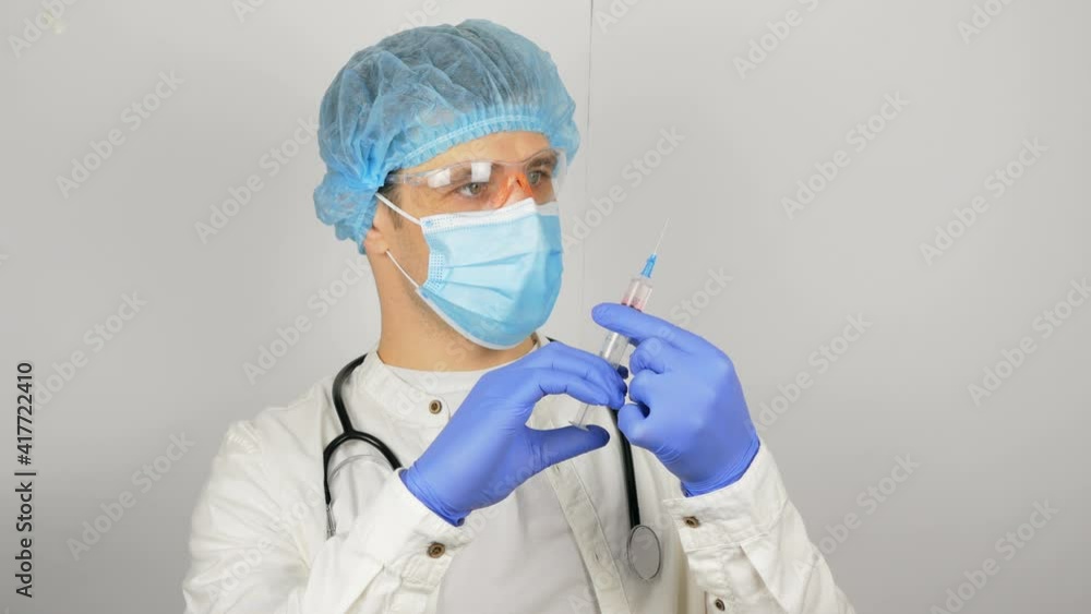Doctor's hands fill the syringe with vaccine, preparing for the injection of the injection to the patient. Doctor's hands fill the syringe with vaccine, preparing for the injection of the injection to the patient.