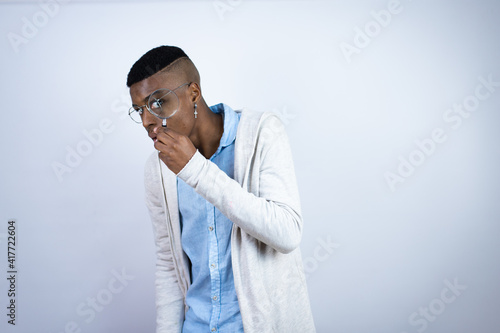 Young handsome african american man wearing casual clothes surprised looking through a magnifying glass
