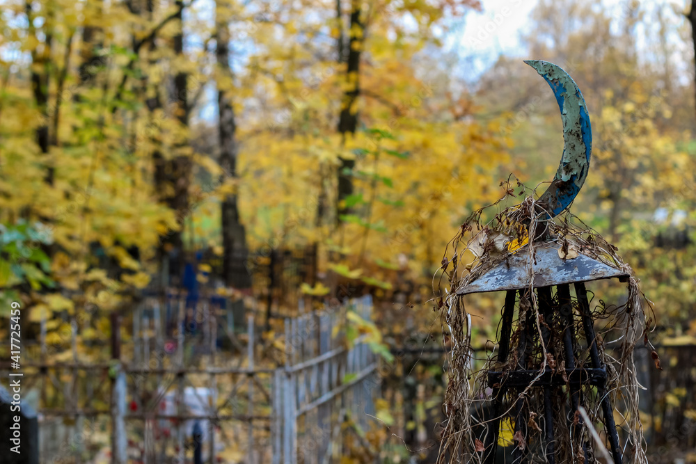 Naklejka premium religious symbol of Islam iron steel crescent moon near the grave in the cemetery
