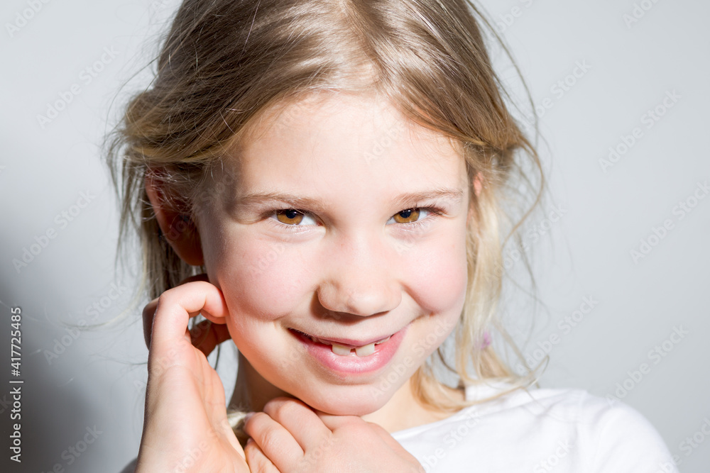 Portrait d'une enfant fille blonde avec ses mains au visage Portrait d'une enfant fille blonde avec ses mains au visage