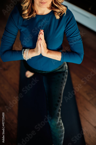 Middle aged yogi woman doing yoga at home