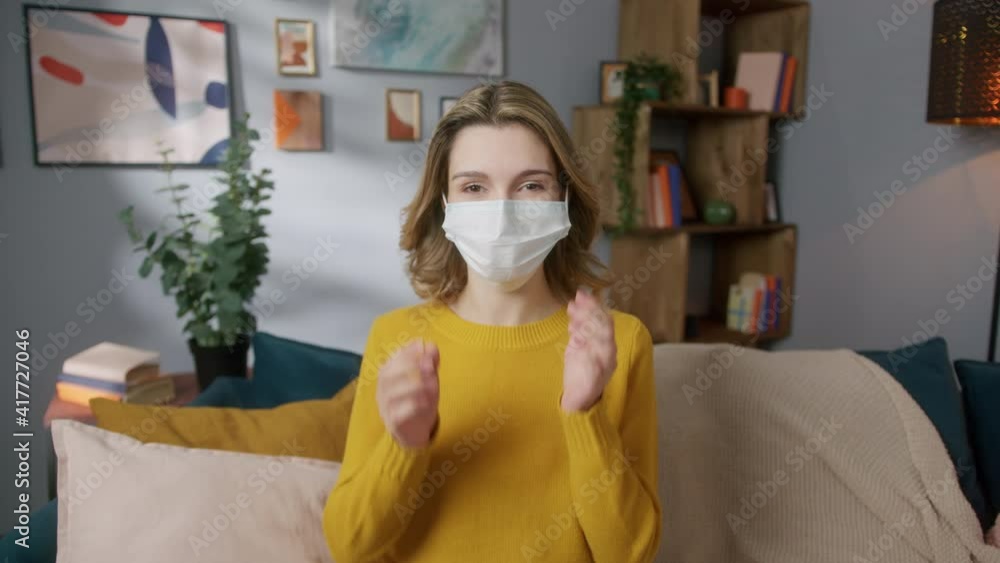 Happy cheerful young woman teenager portrait in medical safety protection mask coronavirus covid 19 lockdown. Student relaxing indoors after college or university, generation z millennial. Happy cheerful young woman teenager portrait in medical safety protection mask coronavirus covid 19 lockdown. Student relaxing indoors after college or university, generation z millennial.