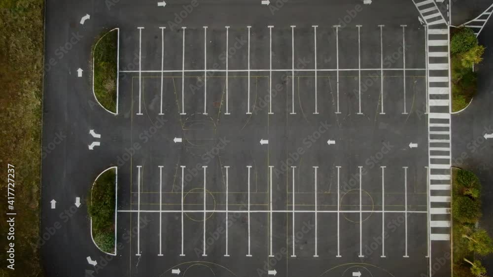 A slow ascend overhead drone shot of an empty car park. A slow ascend overhead drone shot of an empty car park.